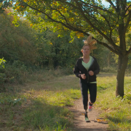 Cassie running in a park listing