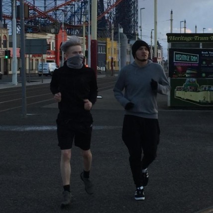 Two men running next to each other. 