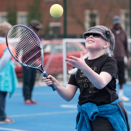 Girl with visual impairment playing tennis.