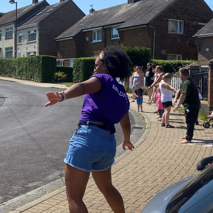 Woman instructing a dance session on a street. 