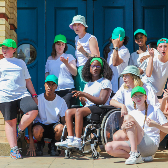 Group of disabled and non-disabled young people taking part in a street performance.